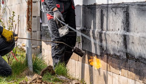 installation of protective waterproofing on the foundation and walls of the building. warmed by an open fire.