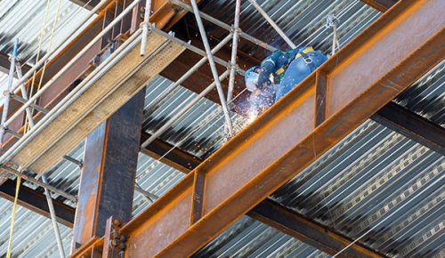 A male welding steel on a girder at heights, on a building structure in Mexico Guadalajara Latin America